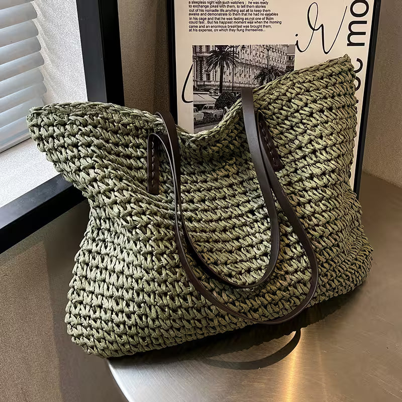 Green woven handbag with a brown strap on a wooden surface.