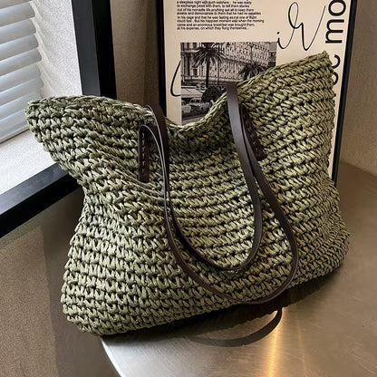 Green woven handbag with a brown strap on a wooden surface.