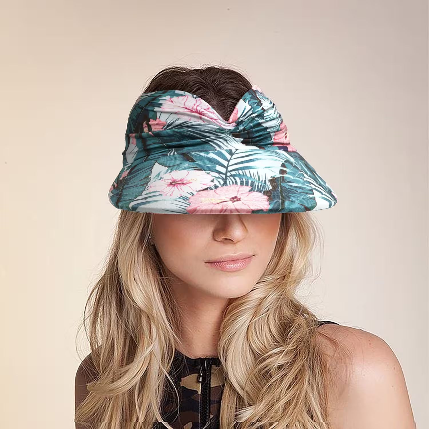 Woman wearing a floral visor hat against a beige background
