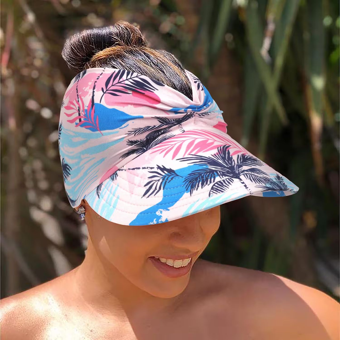 Woman wearing a colorful visor with palm leaf pattern outdoors