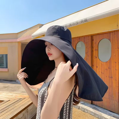 Woman wearing a large black sun hat outdoors