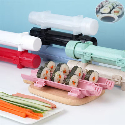 Sushi-making kit with colorful rollers and pre-made sushi on a white surface.