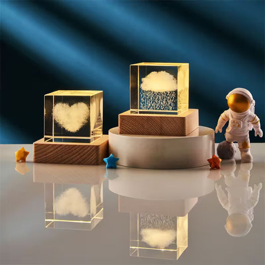 Decorative cloud-shaped lights in clear blocks on a reflective surface with a dark blue gradient background.