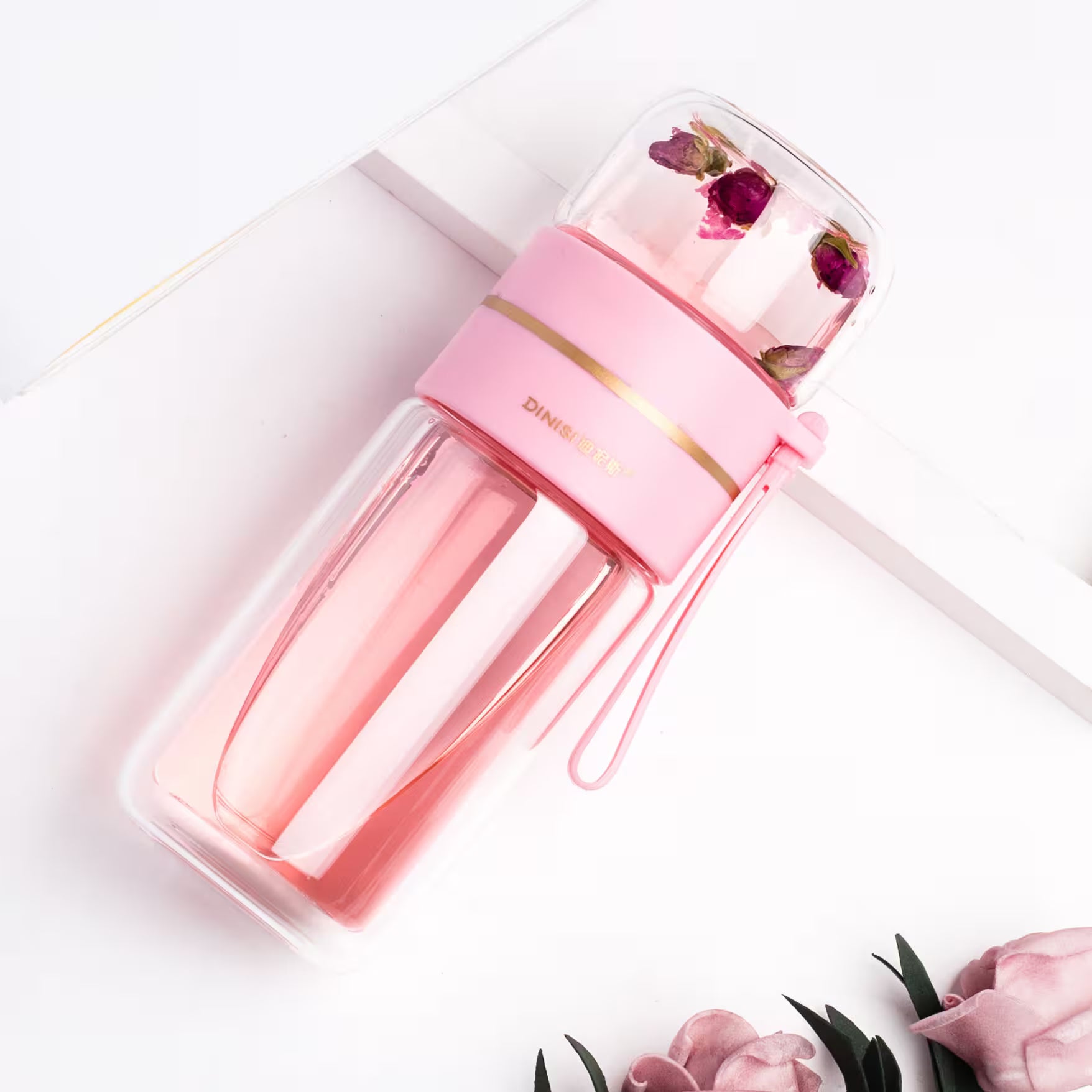 Pink water bottle with floral design on a white background