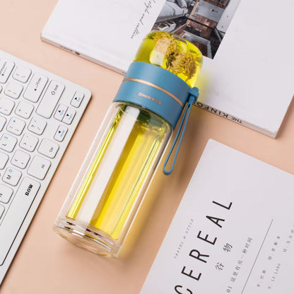 Clear water bottle with blue lid on a desk with a keyboard and books