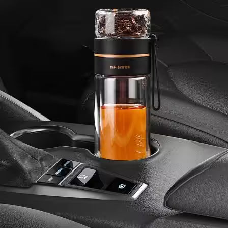 Glass travel mug with a black lid on a car cup holder