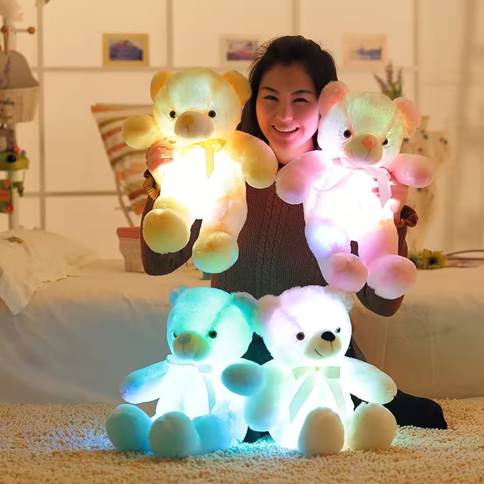 Person holding glowing teddy bears in a bedroom setting