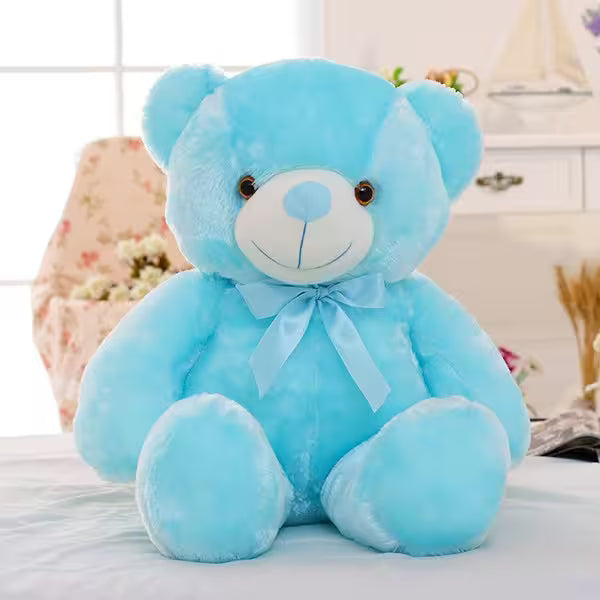 Blue teddy bear with a bow on a light-colored surface