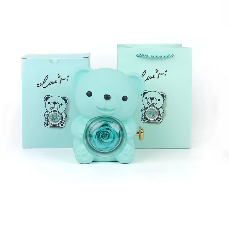 Turquoise teddy bear-shaped container with a rose inside, accompanied by matching cards on a white background.