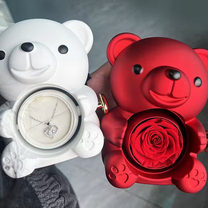 White bear-shaped jewelry box with a necklace and red bear-shaped box with a rose inside, held by a hand.