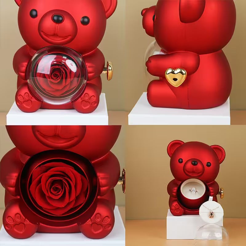 Red teddy bear with a glass ball containing a rose, heart-shaped padlock, and ring inside.