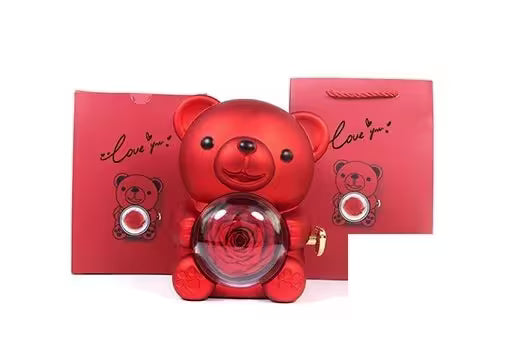 Red teddy bear-shaped container with a rose inside, set against a white background.