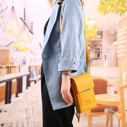 Person holding a yellow handbag in an indoor setting with blurred background