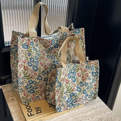 Two floral-patterned tote bags on a wooden surface with a dark background