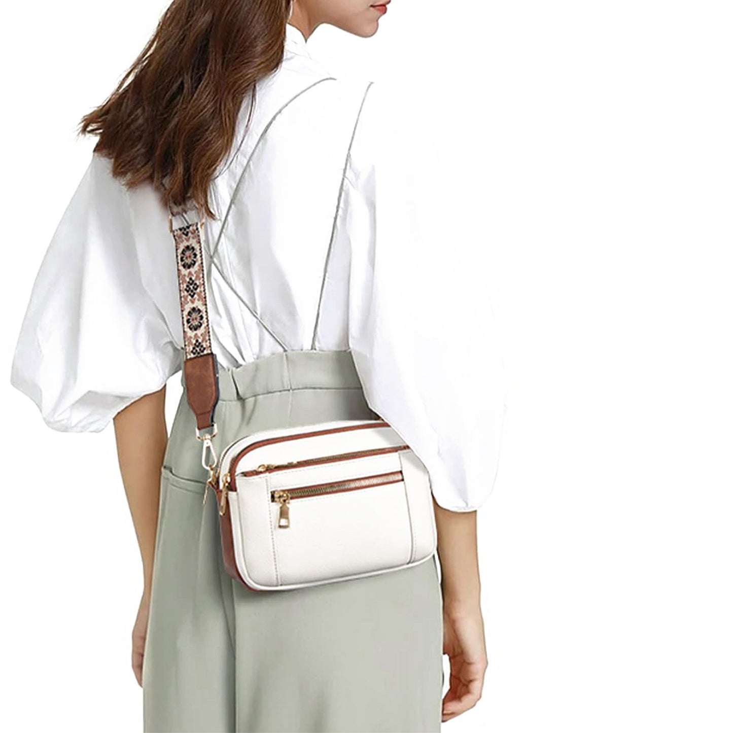 Woman wearing a white blouse and light green pants with a white crossbody bag.