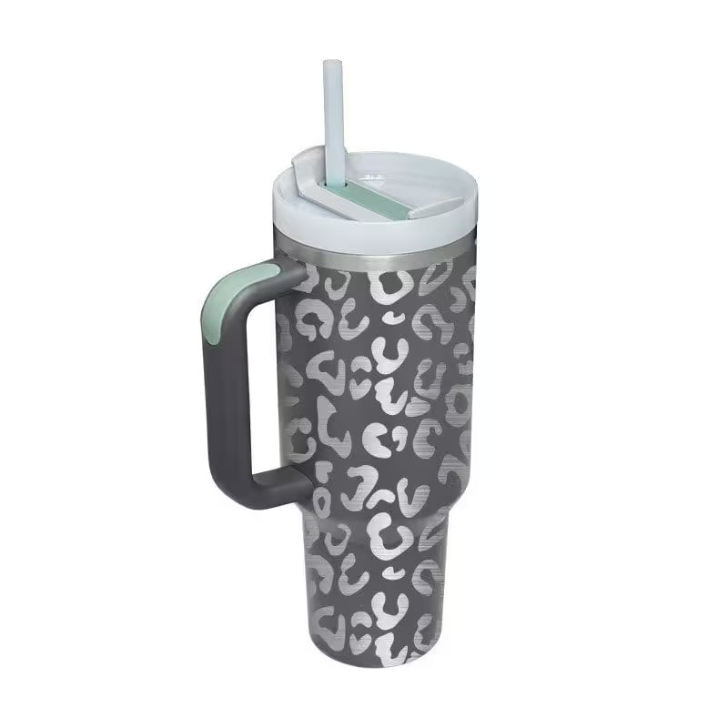 Gray tumbler with white pattern, handle, and straw on a white background