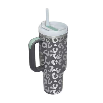 Gray tumbler with white pattern, handle, and straw on a white background