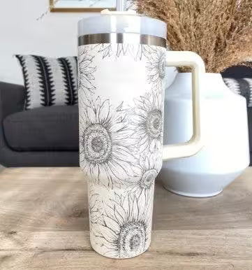 White tumbler with floral design on a wooden surface