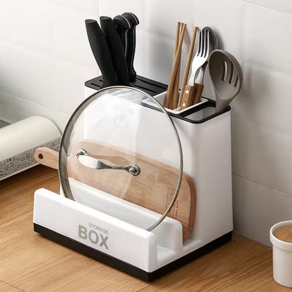 Kitchen utensil holder with cutting board, knives, and other tools on a wooden surface.