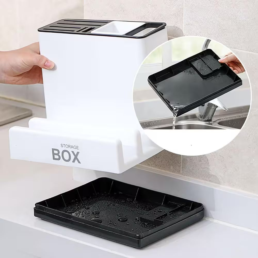 Storage box with a black tray being rinsed under running water in a kitchen setting.