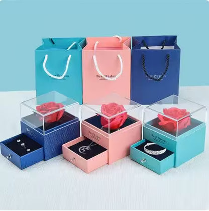 Jewelry boxes with roses and accessories on a light blue background
