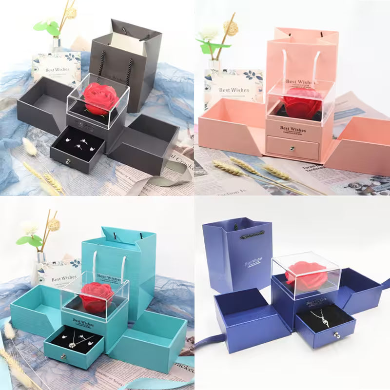 Four different colored jewelry boxes with a rose and necklace inside, on a textured surface.