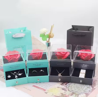 Set of jewelry boxes with red roses and necklaces on a light background