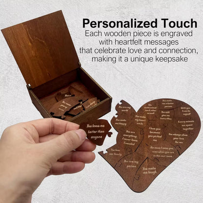 Wooden heart-shaped puzzle with engraved messages in an open box, on a light gray background.