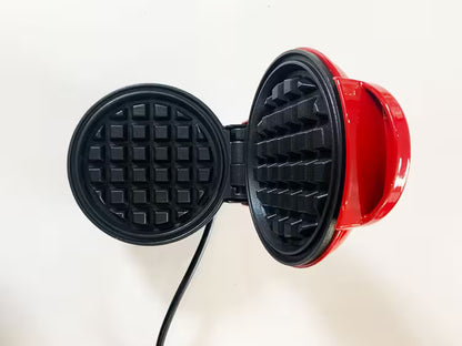 Red and black waffle maker on a white background