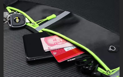 Black pouch with green zipper containing a phone, cards, and keys on a textured black surface.