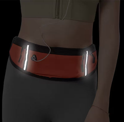 Person wearing a reflective waist bag on a dark background