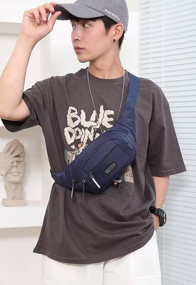 Person wearing a navy blue waist bag, gray cap, and brown t-shirt with visible branding.