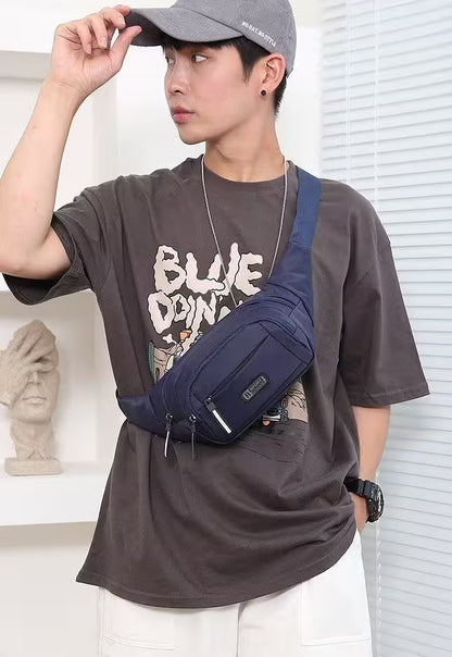 Person wearing a navy blue waist bag, gray cap, and brown t-shirt with visible branding.