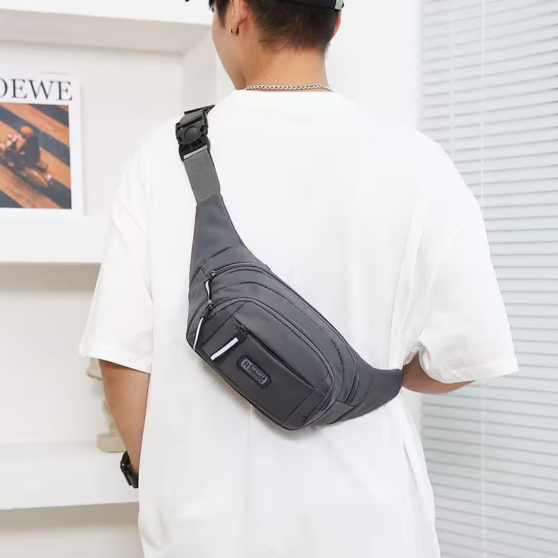 Person wearing a gray crossbody bag indoors