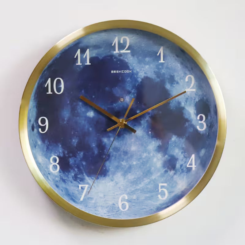 Wall clock with moon design and gold frame on a white background
