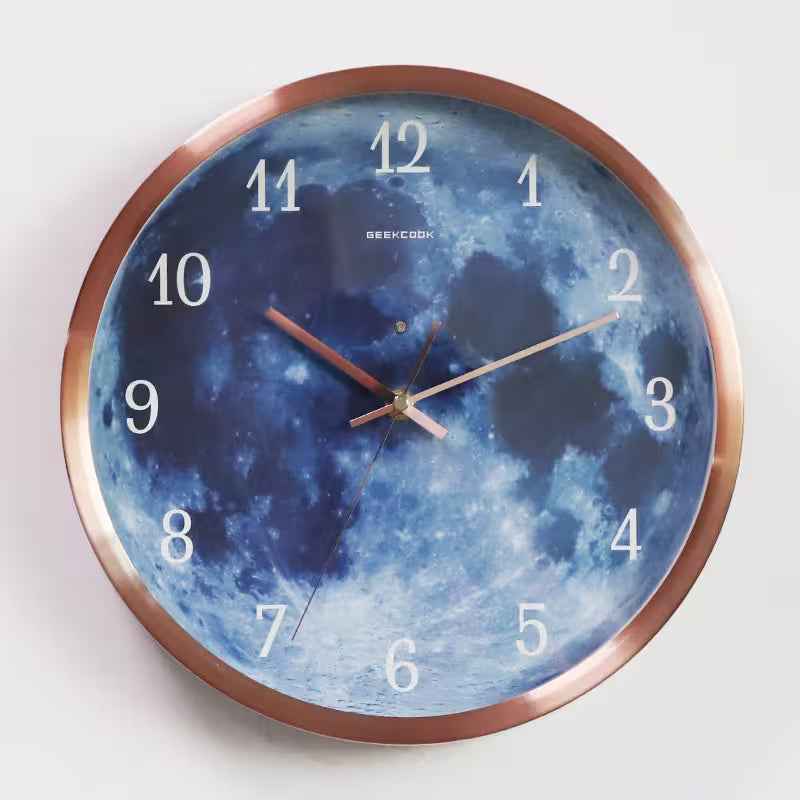 Wall clock with moon design and metallic frame on a white background