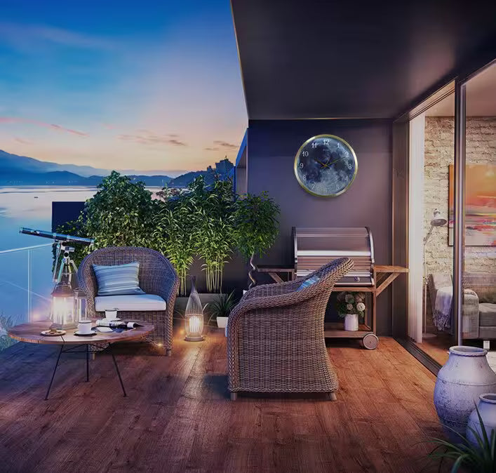 Modern living room with a view of a lake at sunset, featuring wicker chairs and a wall clock.