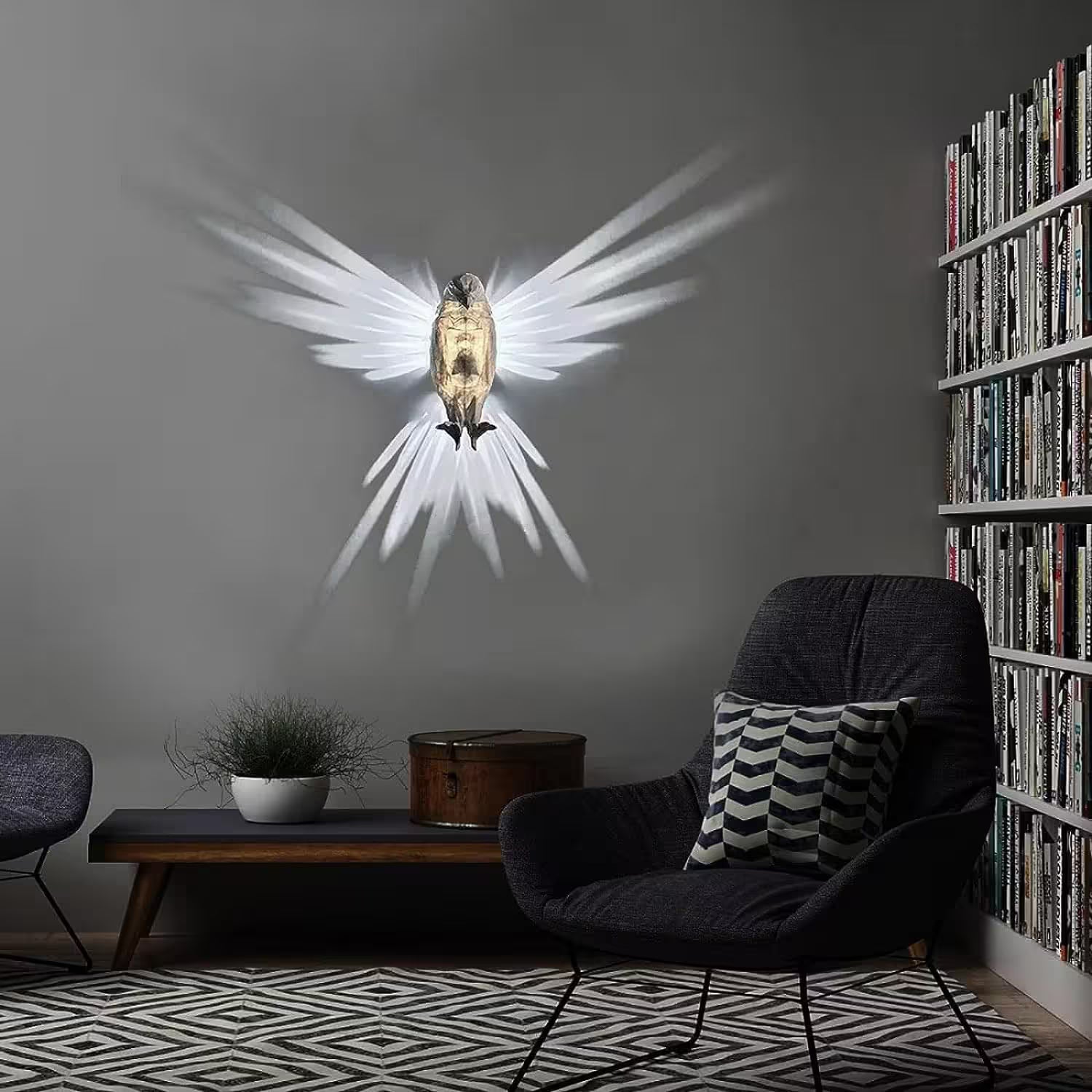 Modern living room with a wall-mounted angel sculpture, dark armchair, and bookshelf.
