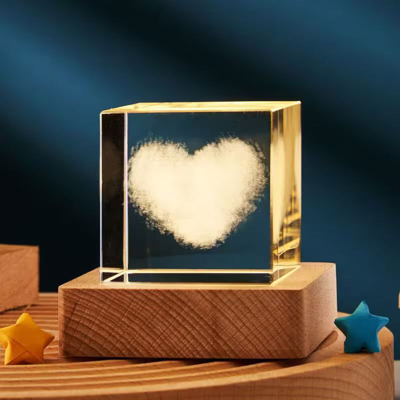 Heart-shaped object inside a transparent cube on a wooden base with a dark blue background
