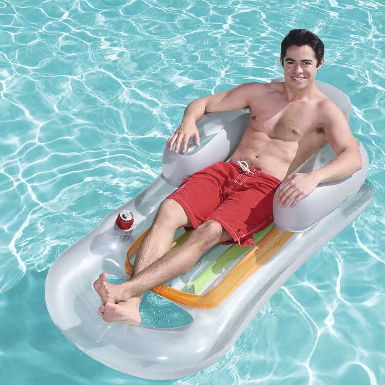 Man lounging on a pool float in clear blue water