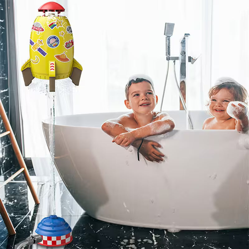 Two children in a bathtub with colorful toys around, including a yellow toy with stickers and a blue and red toy.