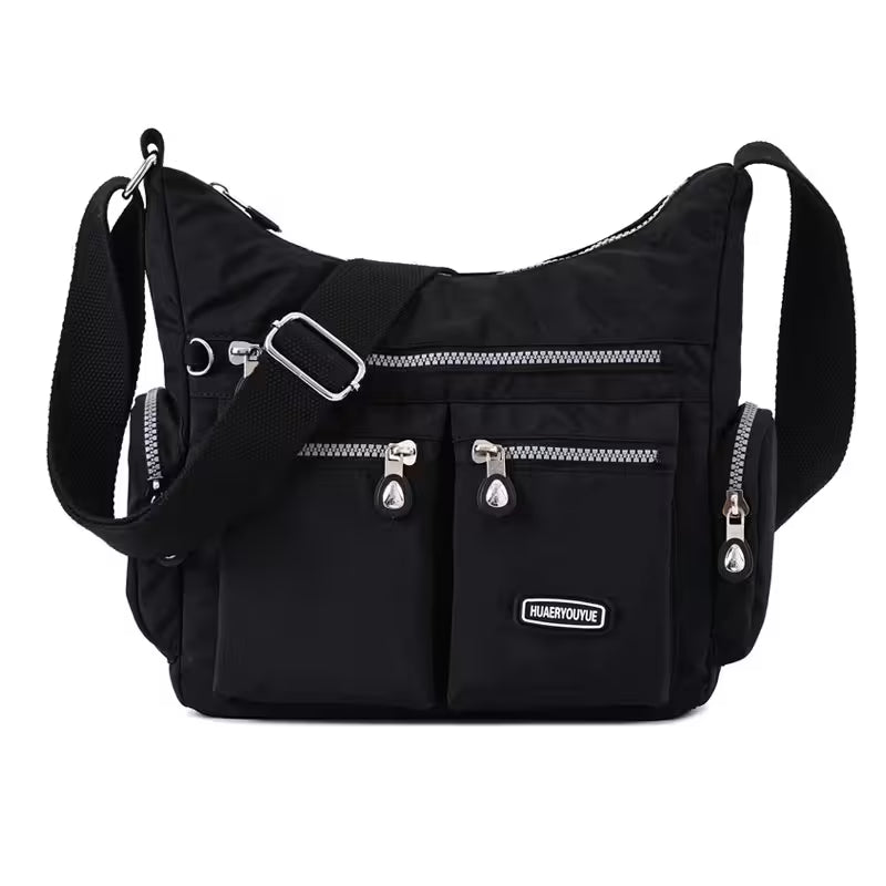 Black shoulder bag with silver zippers and a visible brand logo on a white background