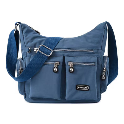 Blue shoulder bag with multiple pockets and a visible brand logo on a white background