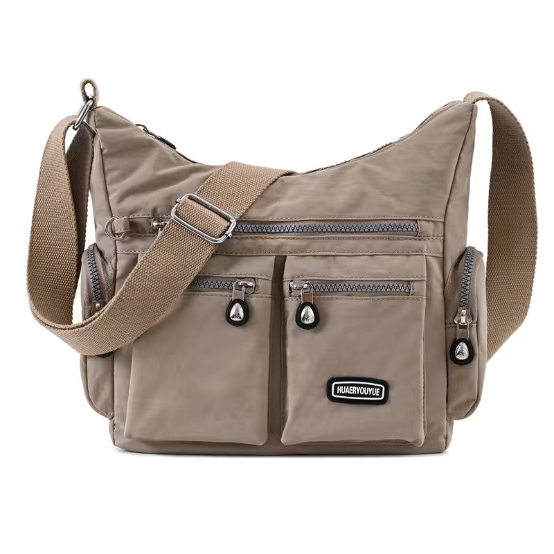 Beige shoulder bag with multiple pockets and a visible brand logo on a white background