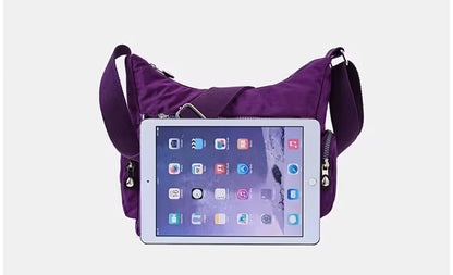 Purple crossbody bag with a tablet device on a white background