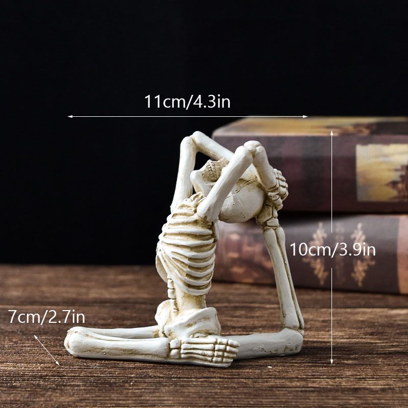 Skeletal yoga pose figurine with measurements on a dark background