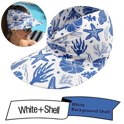 White visor with blue sea-themed pattern worn by a person, with 'White + Shell' branding.