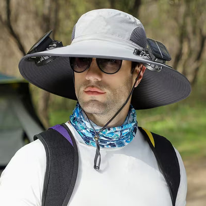 Man wearing a wide-brimmed hat with solar panels, sunglasses, and a backpack outdoors.