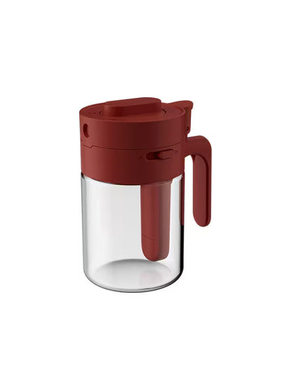 Clear glass container with a red lid and handle on a white background