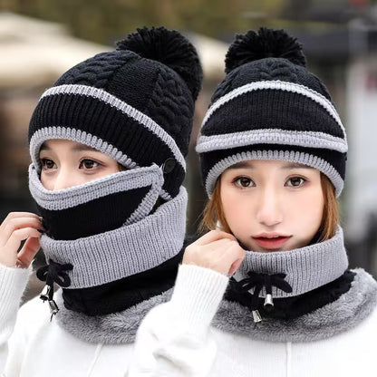 Two people wearing black and gray knit hats and scarves with pom-poms.